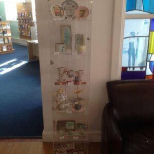 Artwork from the Craft Cabinet displayed in a glass container on shelves
