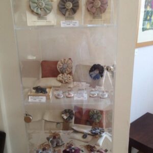 Artwork from the Craft Cabinet displayed in a glass container on a shelf