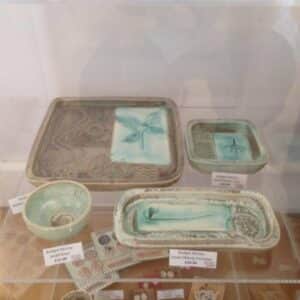 Artwork from the Craft Cabinet displayed in a glass container on a shelf