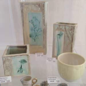 Artwork from the Craft Cabinet displayed in a glass container on a shelf