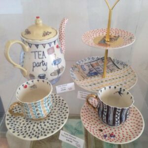 Artwork from the Craft Cabinet displayed in a glass container on a shelf